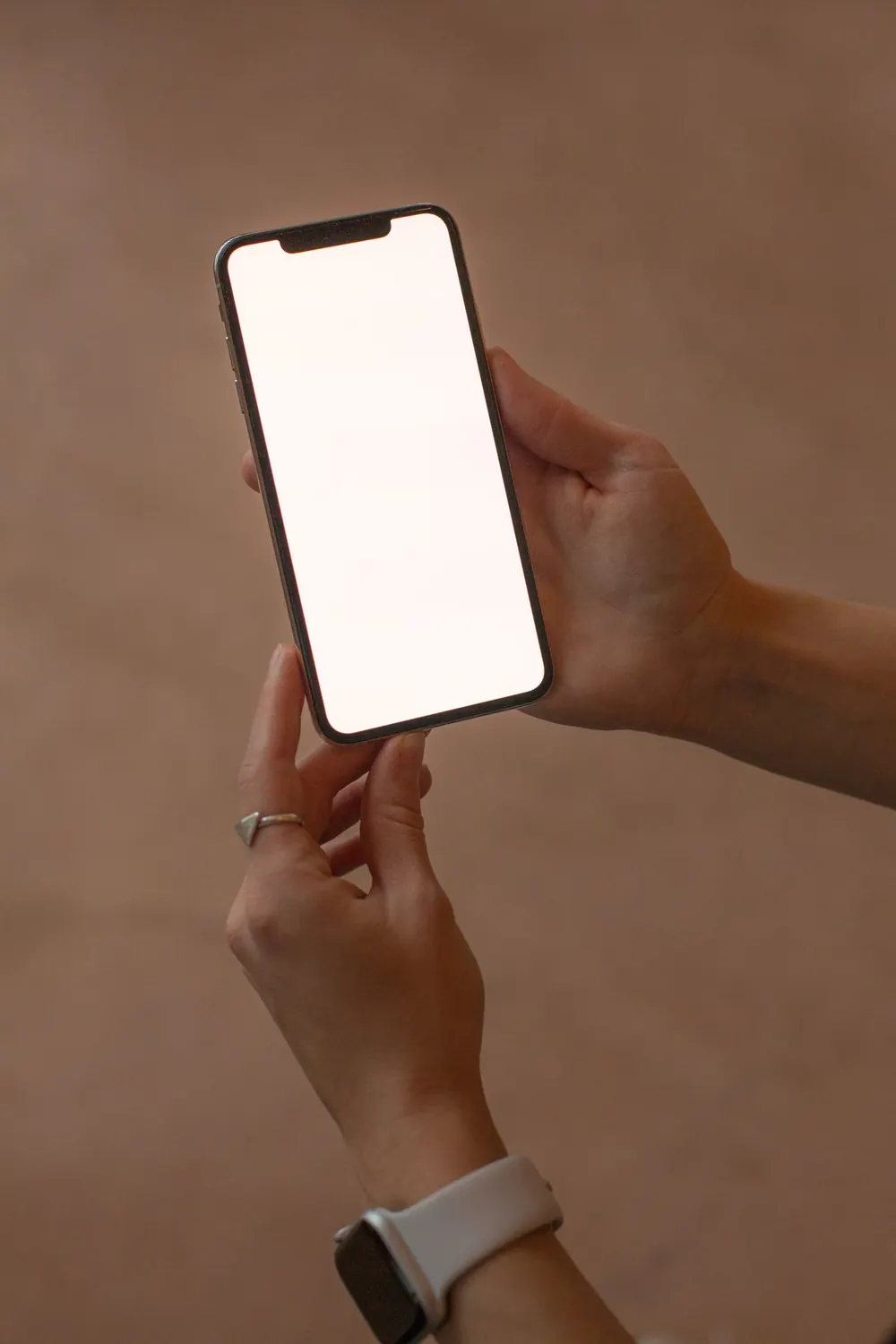 Eine Hand hält ein Smartphone mit leerem Bildschirm.