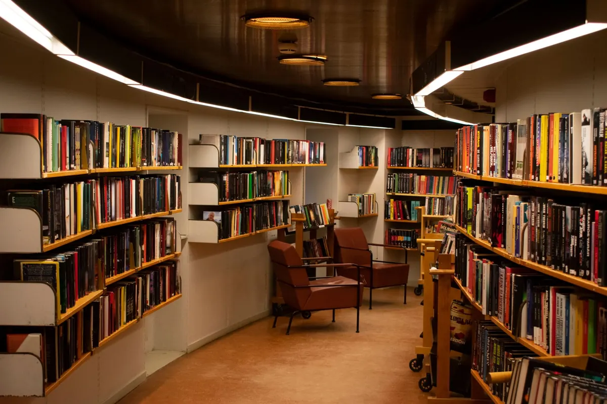 Bibliothek mit Bücherregalen und Ledersesseln.
