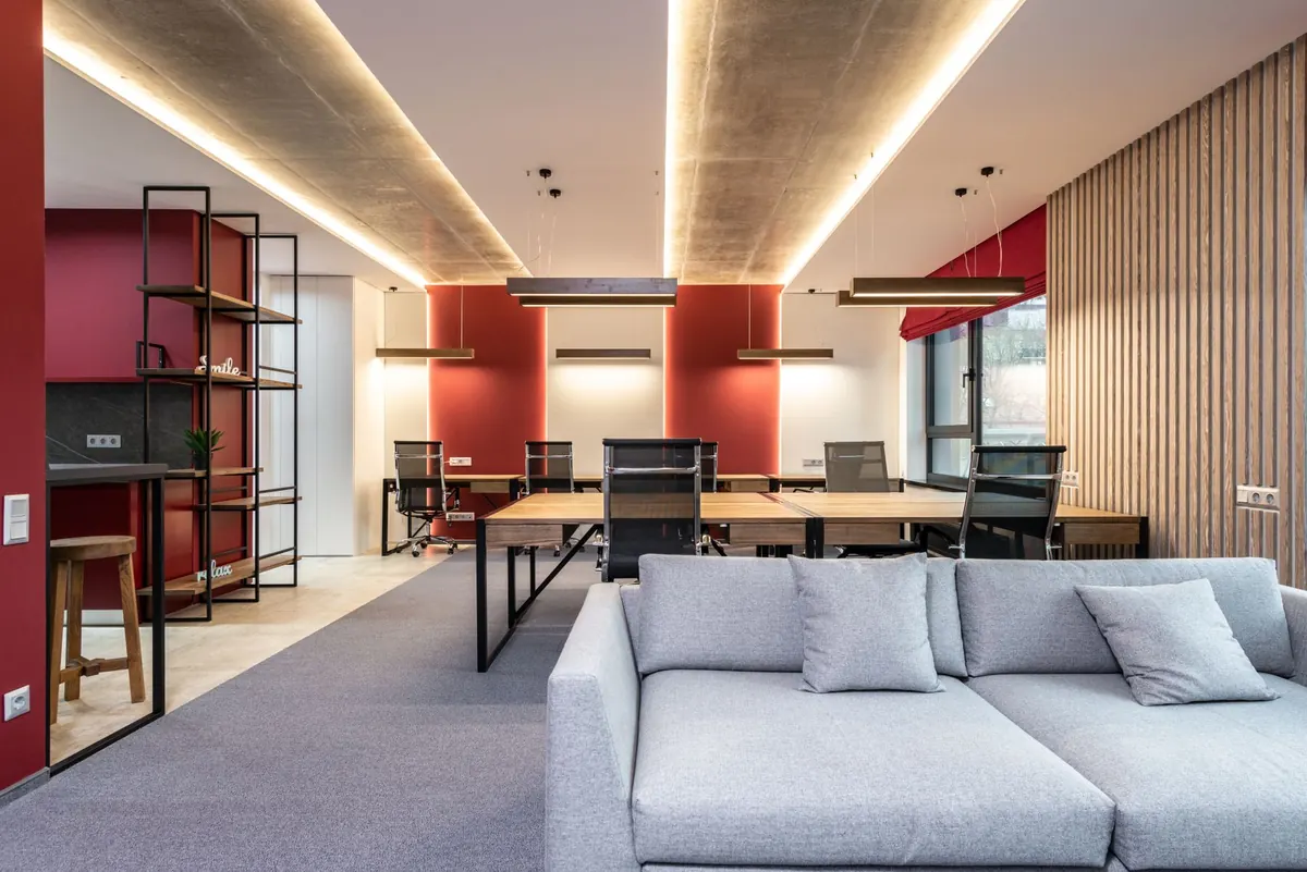 Leeres Büro mit Sofa und Arbeitsplätzen.